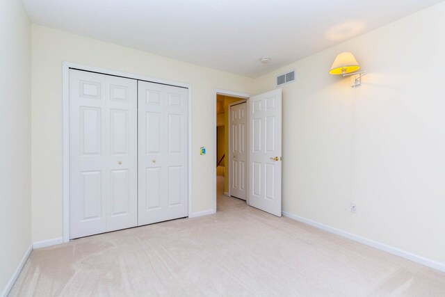 unfurnished bedroom featuring carpet, baseboards, and a closet