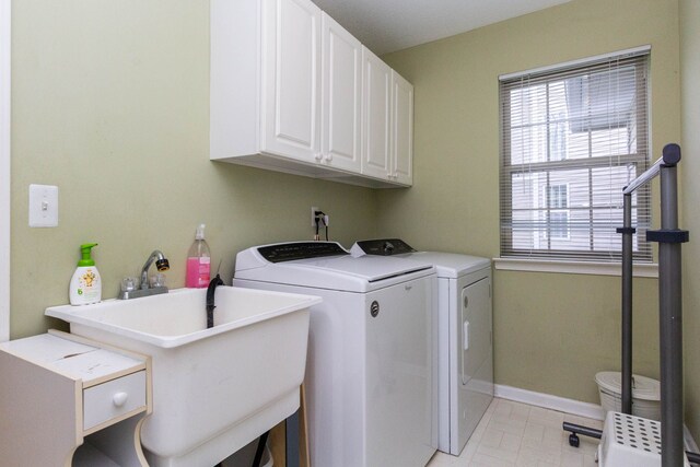 washroom with independent washer and dryer, cabinet space, and baseboards