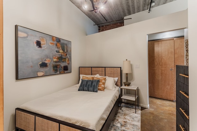 bedroom with finished concrete floors and a towering ceiling
