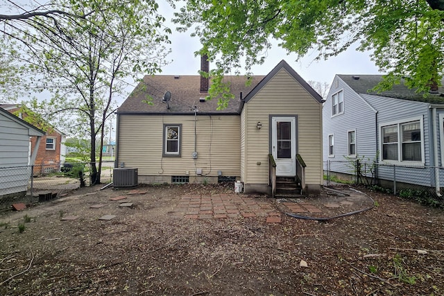 rear view of property with roof with shingles, fence, central AC, entry steps, and a chimney