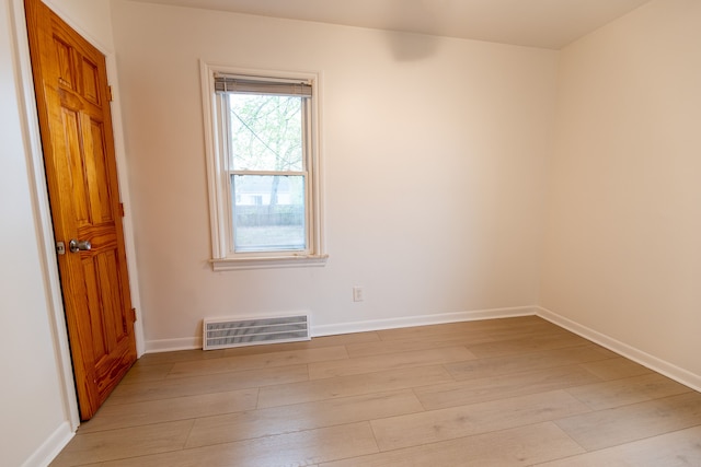 spare room with baseboards, visible vents, and light wood-style floors