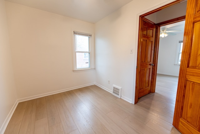 unfurnished room with light wood-style flooring, baseboards, and visible vents