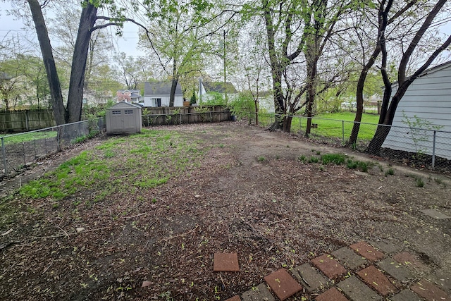 view of yard featuring an outdoor structure, a fenced backyard, and a storage unit