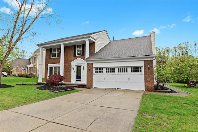 greek revival inspired property with concrete driveway, brick siding, an attached garage, and a front lawn