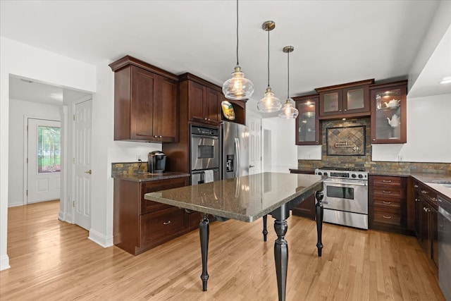 kitchen featuring appliances with stainless steel finishes, light wood-type flooring, decorative backsplash, and dark brown cabinets