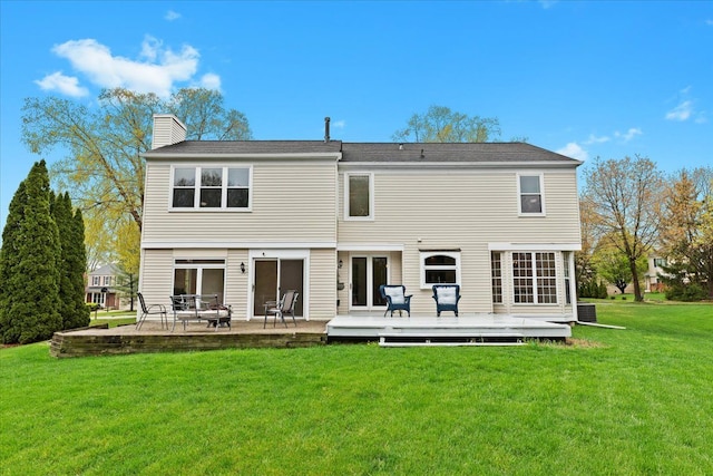 back of house with a yard, a chimney, and a wooden deck