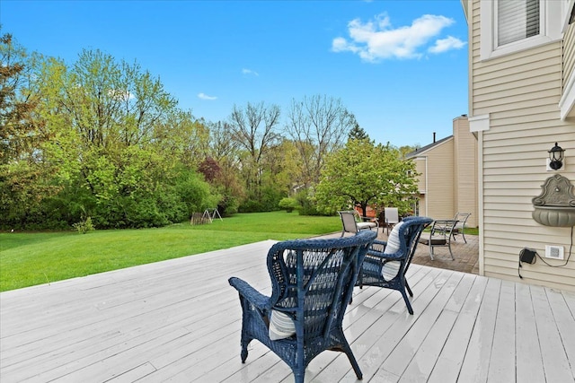 wooden deck with outdoor dining space and a yard
