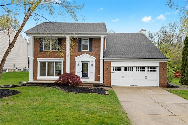view of front of house with brick siding, concrete driveway, an attached garage, a chimney, and a front lawn