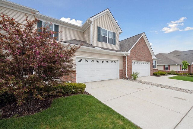 traditional home with brick siding, concrete driveway, and an attached garage
