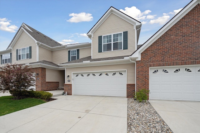 view of front facade with brick siding, concrete driveway, and a garage