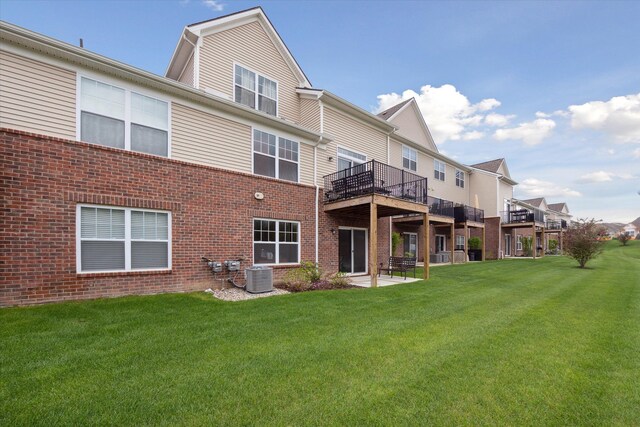 back of house featuring cooling unit, brick siding, a yard, and a wooden deck