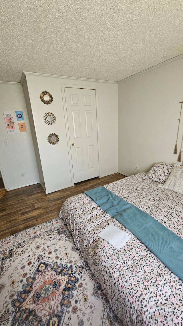 bedroom featuring a textured ceiling and wood finished floors