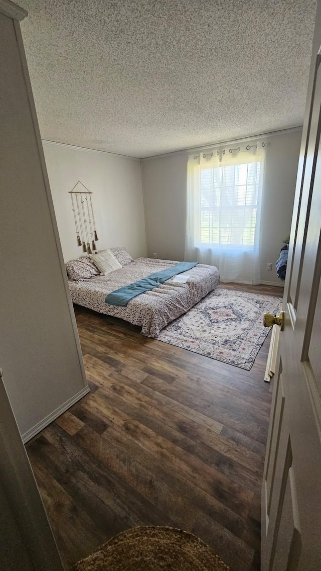 bedroom with dark wood-style floors and a textured ceiling
