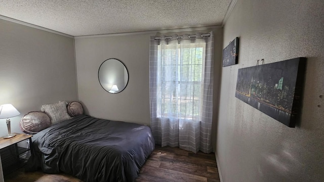 bedroom featuring wood finished floors, a textured ceiling, and ornamental molding