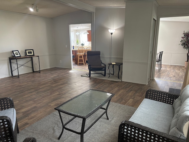 living area with crown molding, wood finished floors, and lofted ceiling