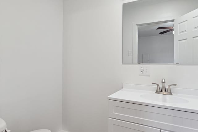 bathroom with vanity, toilet, and a ceiling fan
