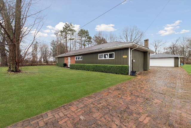 exterior space with a chimney, a front yard, an outdoor structure, and a garage