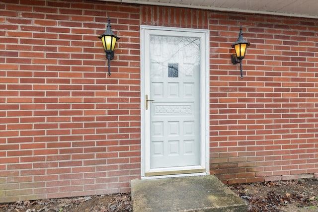 view of exterior entry featuring brick siding