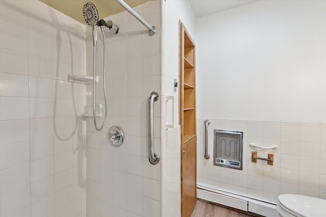 full bathroom with toilet, tiled shower, and baseboard heating