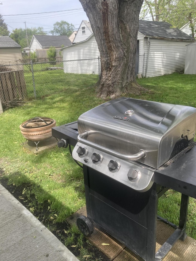 view of yard featuring a storage unit, an outdoor fire pit, fence, and an outdoor structure