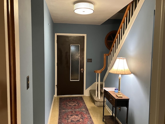 interior space featuring baseboards, stairs, and tile patterned floors
