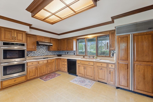 kitchen with under cabinet range hood, brown cabinetry, a sink, black appliances, and light countertops