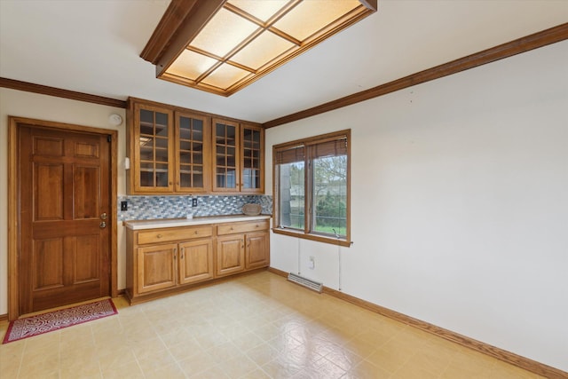 kitchen featuring light countertops, visible vents, baseboards, and ornamental molding