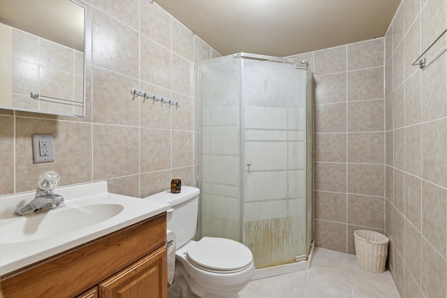 full bathroom featuring toilet, a stall shower, tile patterned floors, tile walls, and vanity