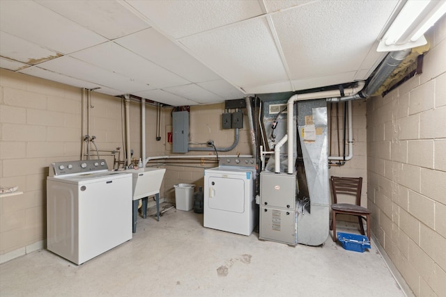 clothes washing area featuring laundry area, heating unit, washer and dryer, and electric panel