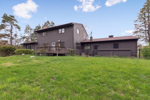 rear view of property featuring fence, a wooden deck, and a chimney
