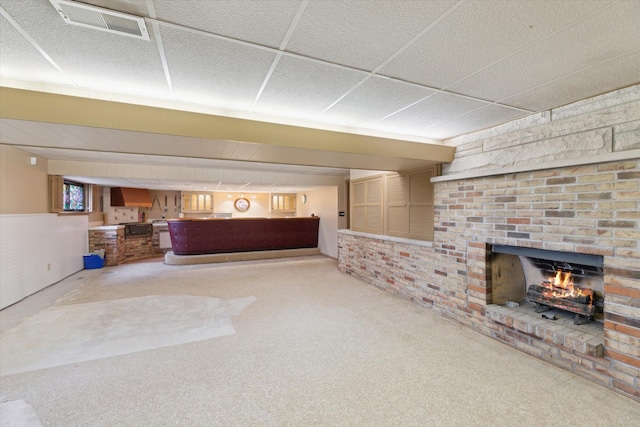 interior space featuring indoor bar, visible vents, a brick fireplace, and carpet