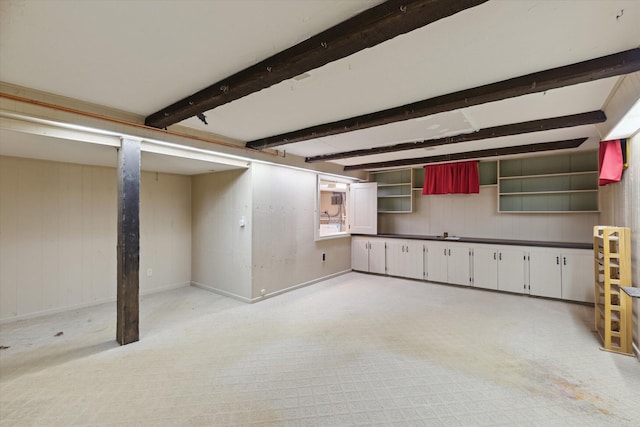 finished basement with light colored carpet, wood walls, and baseboards