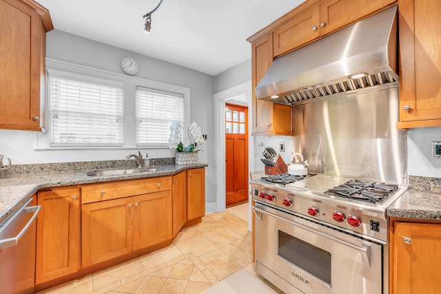 kitchen with light tile patterned floors, a sink, stainless steel appliances, brown cabinetry, and exhaust hood