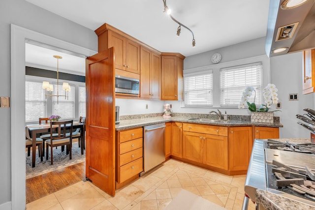 kitchen featuring a sink, extractor fan, brown cabinetry, a chandelier, and appliances with stainless steel finishes