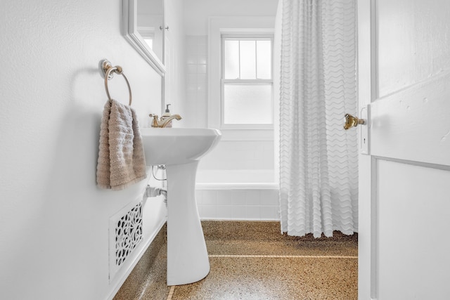 bathroom featuring speckled floor and a sink