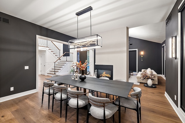 dining room featuring stairway, wood finished floors, baseboards, and visible vents