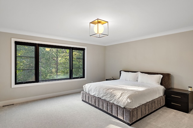 bedroom with baseboards, crown molding, visible vents, and light colored carpet