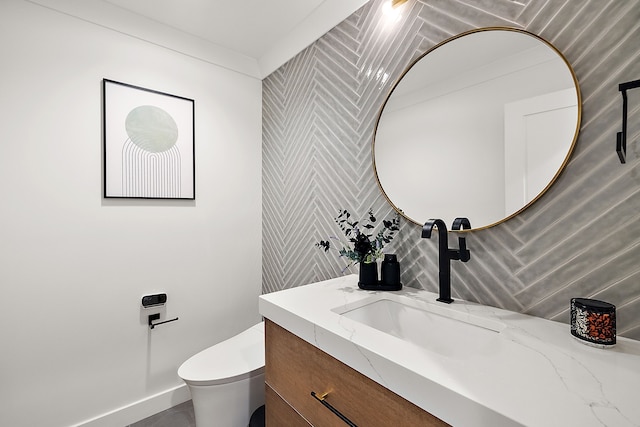 half bathroom with vanity, toilet, and backsplash