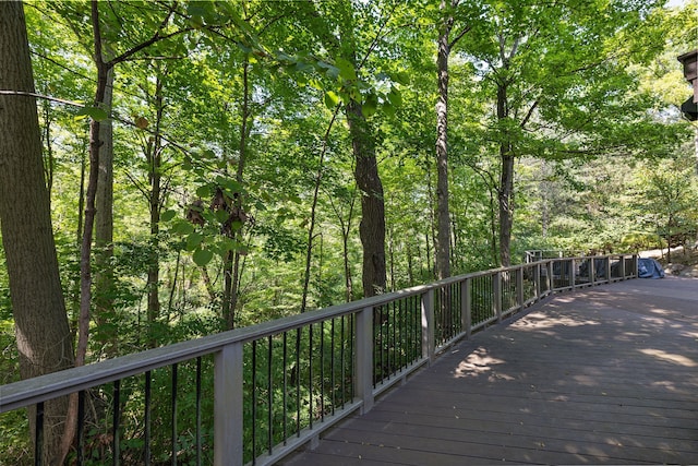 view of community featuring a deck and a forest view