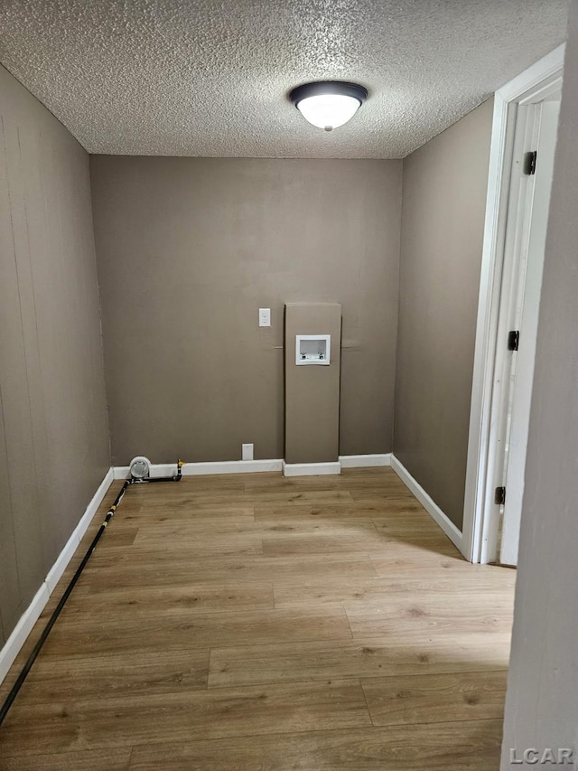 4084 Seneca St, Weston, MI 49289 - clothes washing area with light wood finished floors, laundry area, washer hookup, a textured ceiling, and baseboards