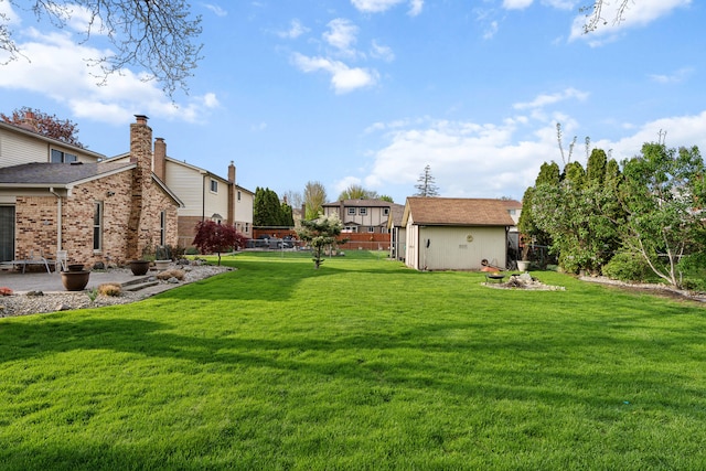 view of yard featuring a patio area, an outdoor structure, fence, and a storage unit