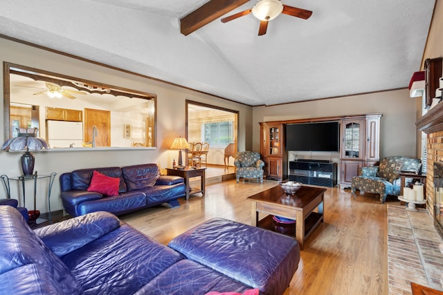 living room with a brick fireplace, ceiling fan, vaulted ceiling with beams, and wood finished floors