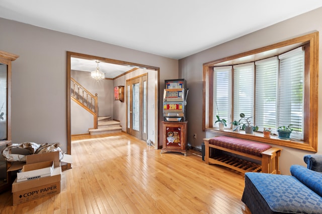 entryway with stairway, an inviting chandelier, light wood-style flooring, and baseboards