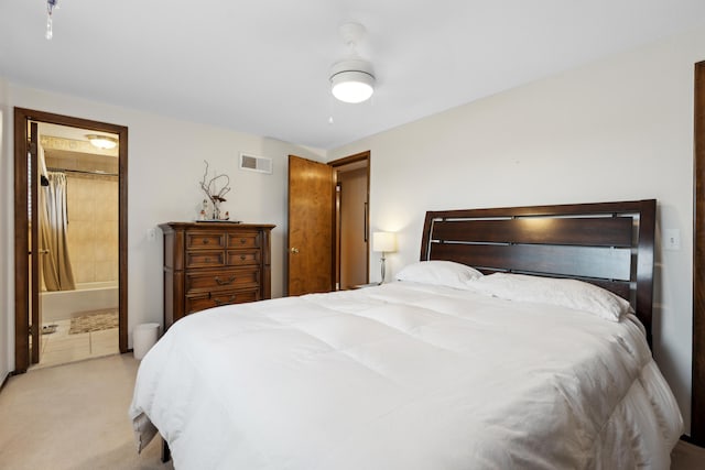 bedroom with connected bathroom, visible vents, and light colored carpet