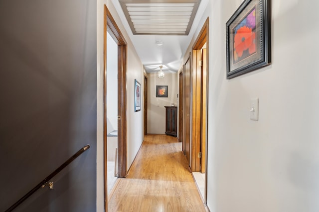 hallway with light wood-style flooring and an upstairs landing