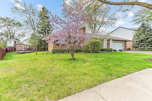 view of front of home with a garage, fence, concrete driveway, a front lawn, and brick siding