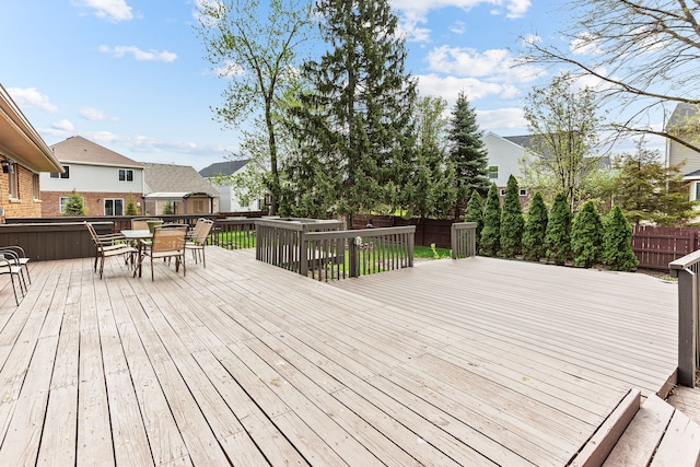 deck with a fenced backyard, outdoor dining area, and a residential view