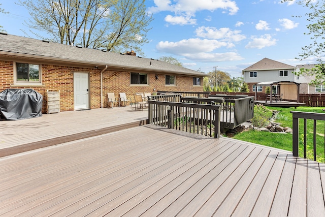 wooden deck with a lawn, area for grilling, outdoor dining area, and fence