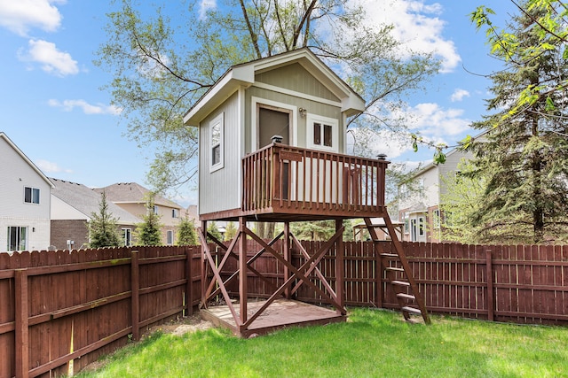 exterior space featuring a fenced backyard, an outbuilding, and a lawn
