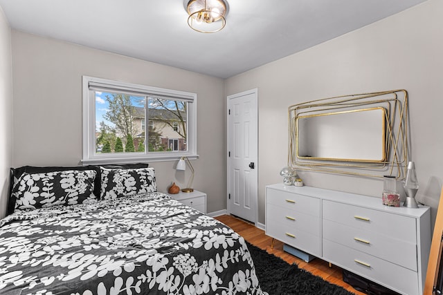 bedroom featuring wood finished floors and baseboards